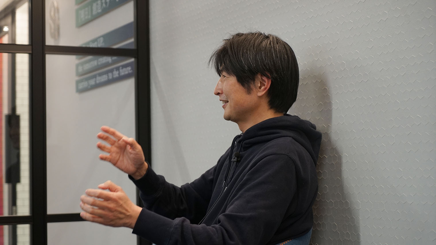 身振り手振りを交えて笑顔でインタビューに答える柴田さんの写真