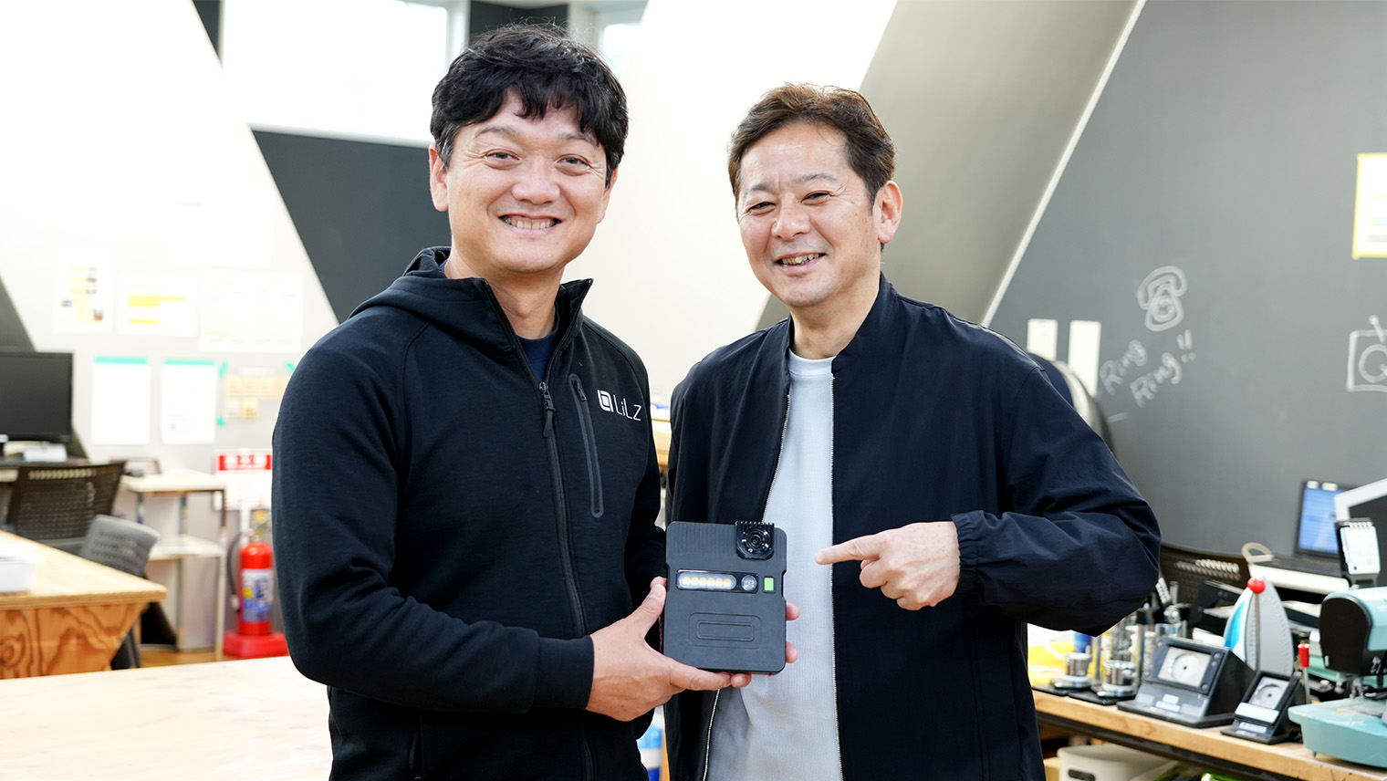 防爆対応IoTカメラ「LC-EX10」を持つ大西さんと水間